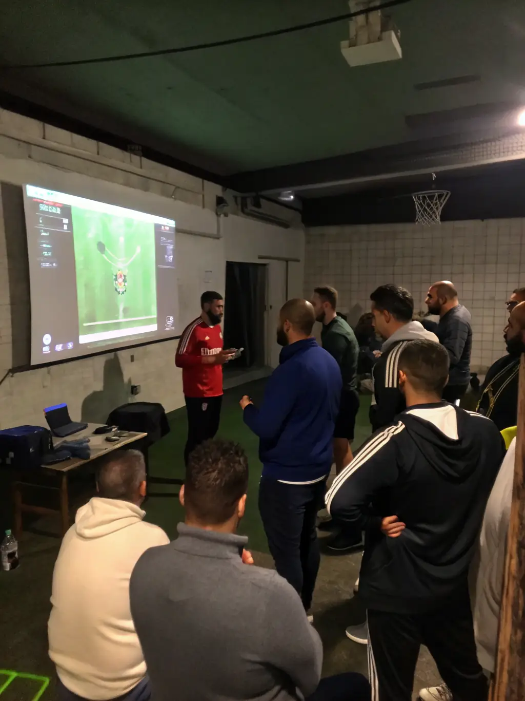 Image of coaches and players reviewing game footage and discussing strategy at ASSOCIATION ATHLÉTIQUE MASSIACOISE – SECTION FOOTBALL.